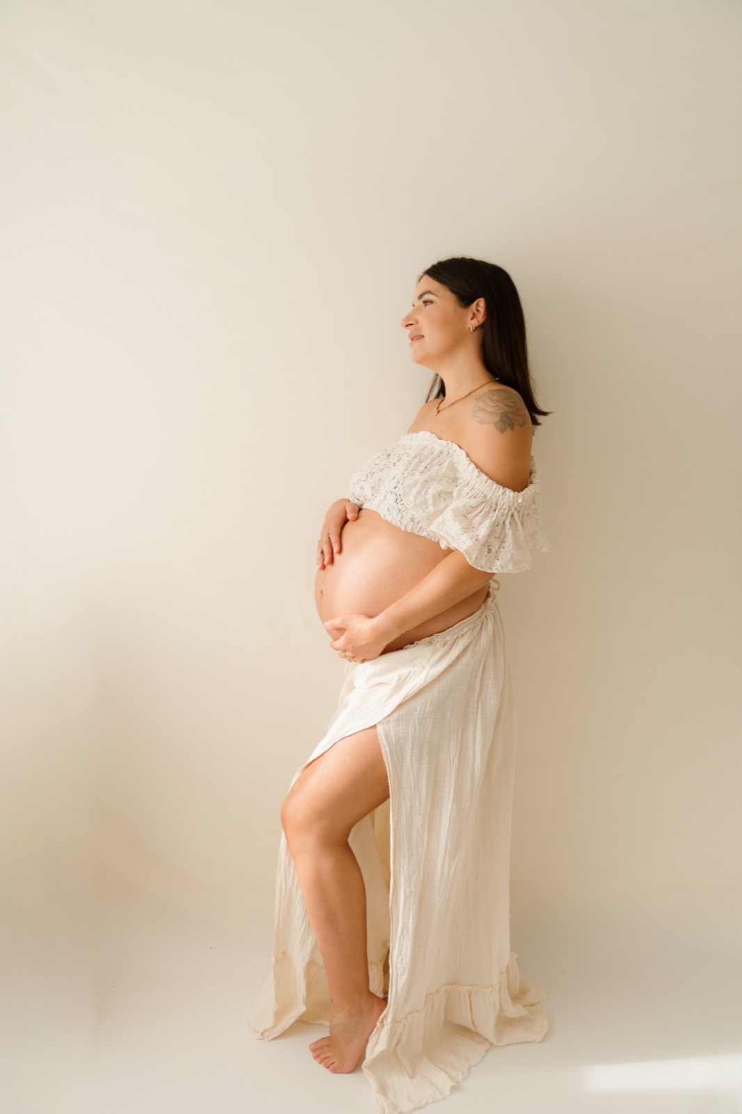 Schwanger Mama am wäisse Kleed hält hire Bauch, Maternity Shooting am Homestudio zu Elvange